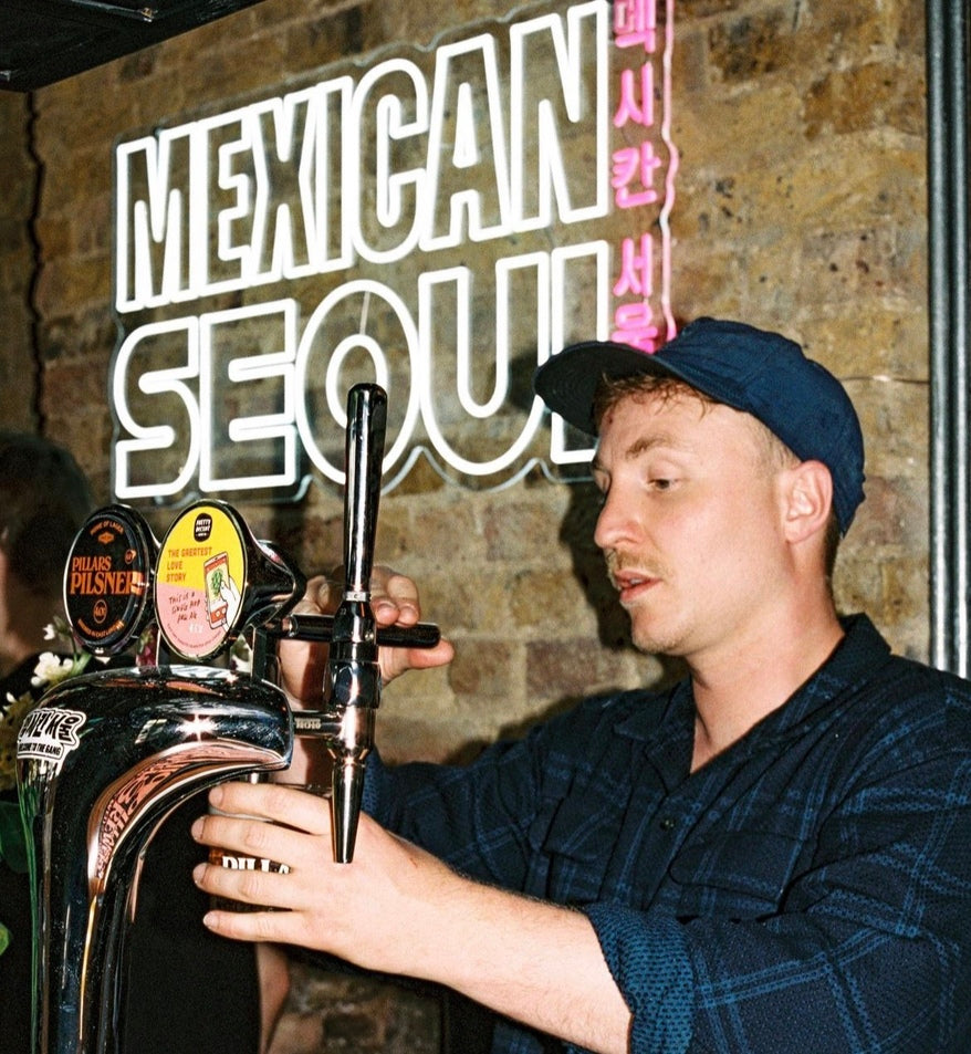 mexican seoul neon sign logo in london restaurant with ice white and pink on a brick wall decor